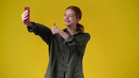 4k video of girl using her phone on yellow background. Video stock 234474563