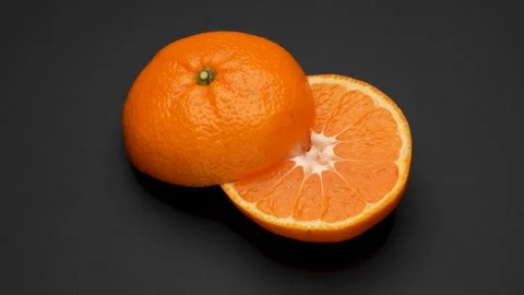 4K video of a halved mandarin orange slowly rotating on a black background. Stock Footage 320587722