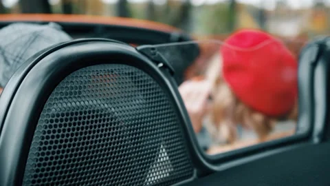 Young Couple Kissing On Bonnet Of Convertible Car High-Res Stock