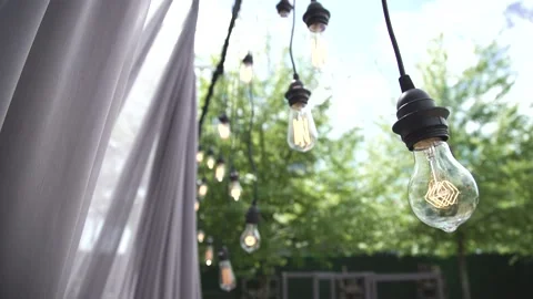 4K video light bulb Edison wired vintage style is hanging during event in nature 動画素材 130273254