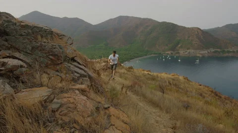 4k video of a man climbing to a mountain and opening his arms. Slow motion. Stock Footage 40470124