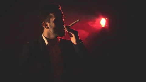 4k video of man drinking alcohol and smoking on dark background. Stock Footage 173207973