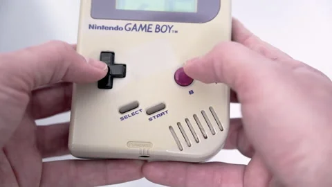 4k video of a man holding a classic Nintendo Game Boy Stock Footage 175388096