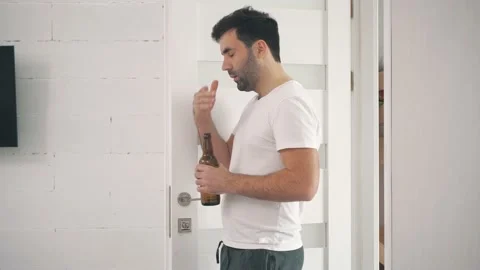 4k video of man opening white door holding a bottle of beer. Stock Footage 141569857