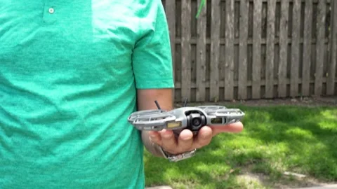 4K video of a man releasing a compact drone from his hand as it takes flight Stock Footage 342078411
