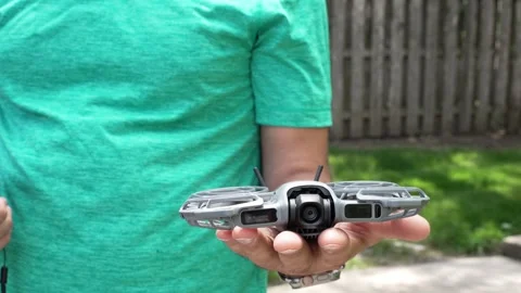 4K video of a man releasing a compact drone from his hand as it takes flight Stock Footage 342078655