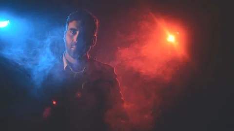 4k video of man in suit posing on black background with blue and pink lights. Stock Footage 171538430
