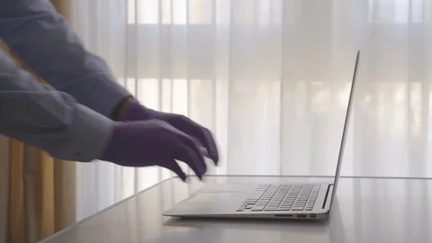 4k video of a man typing into a computer with gloves on to protect himself fr Stock Footage 129603291