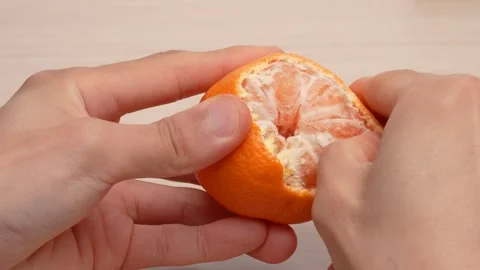 4K video of a mandarin orange being peeled on a table. Stock Footage 320326634