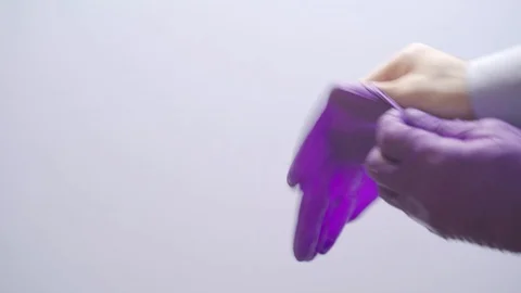 4k Video of man's hands putting on a latex glove to prevent the spread of the Stock Footage 129603302