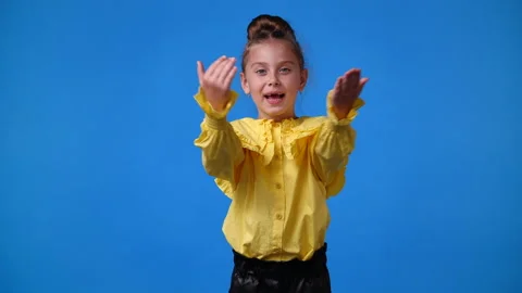 4k video of one cute young girl smiling and sends a kiss of air over blue Stock Footage 233650520