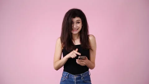 4k video of one girl using her phone over pink background. Stock Footage 236414525