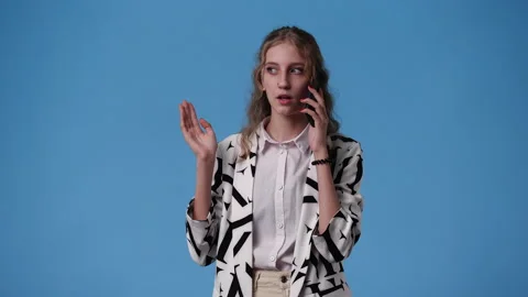 4k video of one girl using her phone over blue background. Stock Footage 238043884