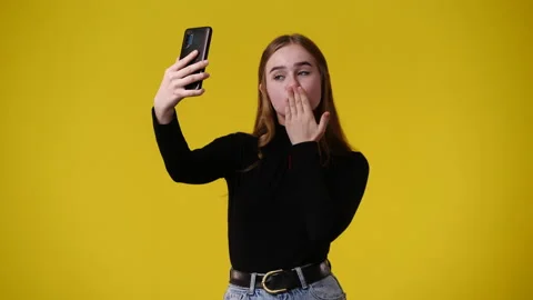 4k video of one girl using her phone over yellow background. Stock Footage 238994338