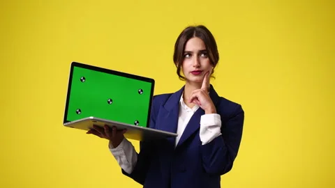 4k video of one girl using chroma key laptop and thinking over yellow background Video stock 241044586