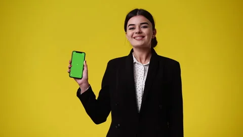 4k video of one girl using chroma key phone and showing thumbs up over yellow Stock Footage 242037032