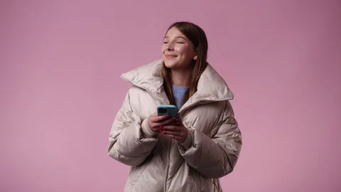 4k video of one girl using her phone over pink background. Stock Footage 243628657