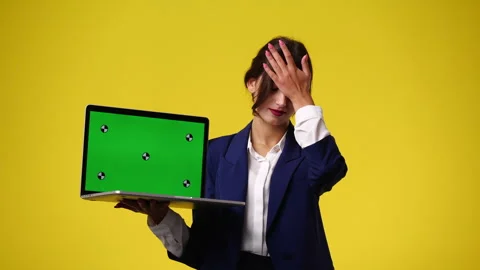 4k video of one girl using chroma key laptop and thinking over yellow background Video stock 244458661