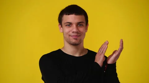 4k video of one man claps his hands and smiling over yellow background. Video stock 237712082