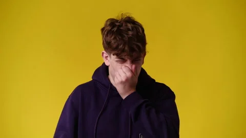 4k video of one man closes the nose against the smell over yellow background. Stock Footage 233228977
