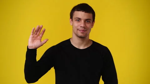 4k video of one man looking at the camera over yellow background. Stock Footage 240444946
