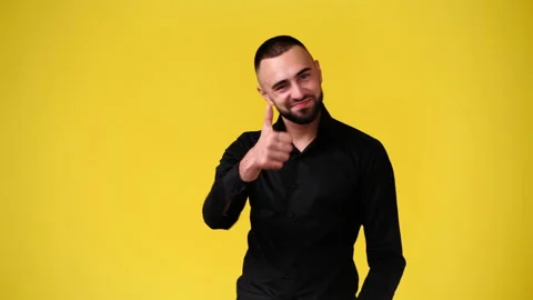 4k video of one man pointing at the camera and showing thumb up on yellow Stock Footage 229991267