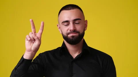4k video of one man with positive facial expression showing two fingers. Stock Footage 229985998