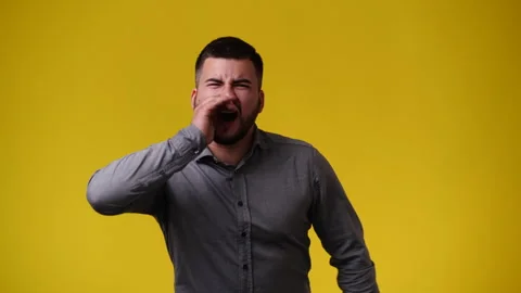 4k video of one man screaming over yellow backgrpound. Stock Footage 240391815