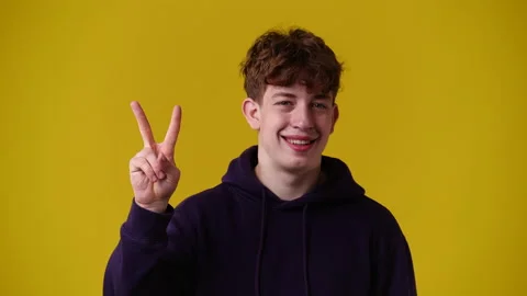 4k video of one man showing two fingers over yellow background. Stock Footage 231647488