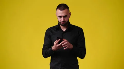 4k video of one man using phone over yellow background. Stock Footage 235219432