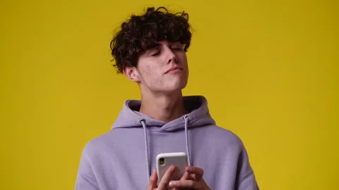 4k video of one man using phone over yellow backgrpound. Stock Footage 240750524