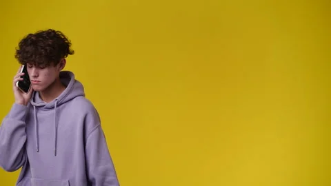 4k video of one man using phone over yellow backgrpound. Stock Footage 240751653