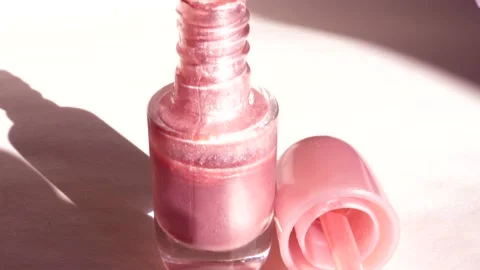 4k video, Open bottle of pink nail polish with a brush on a white background Stock Footage 172560310