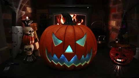 4k video of pumpking changing colours on spooky fire place. wram flickering Stock Footage 140882260