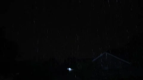 4K video of rain falling at night, illuminated by backlight. Raindrops visible Stock Footage 317950084