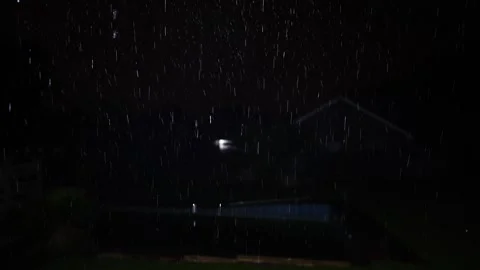 4K video of rain falling at night, illuminated by backlight. Raindrops visible Stock Footage 317950352