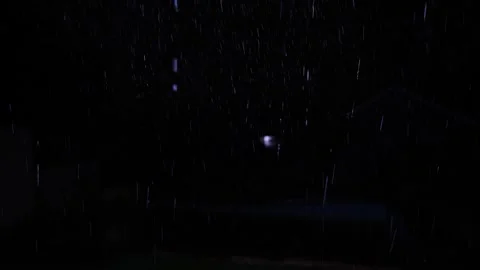 4K video of rain falling at night, illuminated by backlight. Raindrops visible Stock Footage 317950475