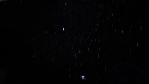 4K video of rain falling at night, illuminated by backlight. Raindrops visible Stock Footage 317950536