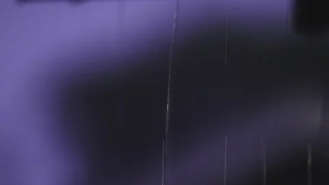 4K video of rain falling at night, illuminated by backlight. Raindrops visible Stock Footage 317950759