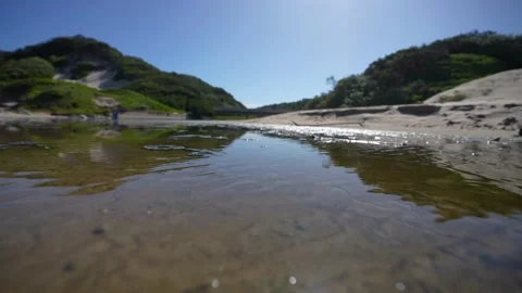 4K video of a river flowing through a lagoon at the Indian ocean over the beach Stock Footage 221427890