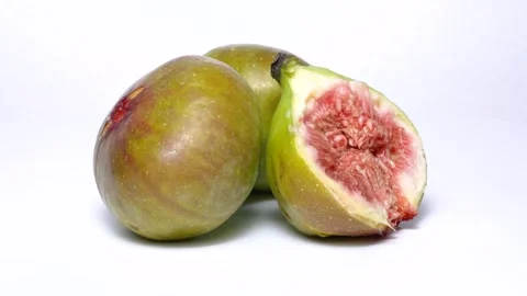 4K video showing one fig and a halved fig rotating on a white background. Stock Footage 274520919