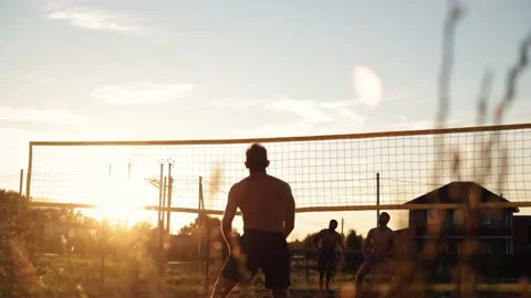 4k video Team playing beach valleyball on sunset. Youth having fun on beach at Stock Footage 211799497