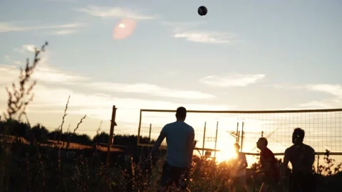 4k video Team playing beach valleyball on sunset. Youth having fun on beach at Stock Footage 212172307