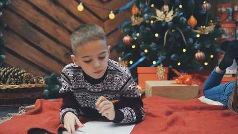 4k video of thoughtful boy looking for something to write in a letter to santa Stock Footage 119344400