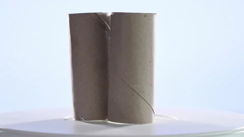 4k video of three cardboard rolls of the worn toilet paper spinning on a turn Stock Footage 144847374