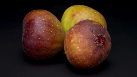 4K video of three figs turning on black background. Stock Footage 310164218