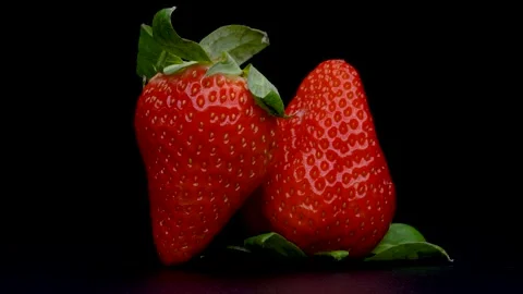 4K video of two turned strawberries on black background. Stock Footage 289419693