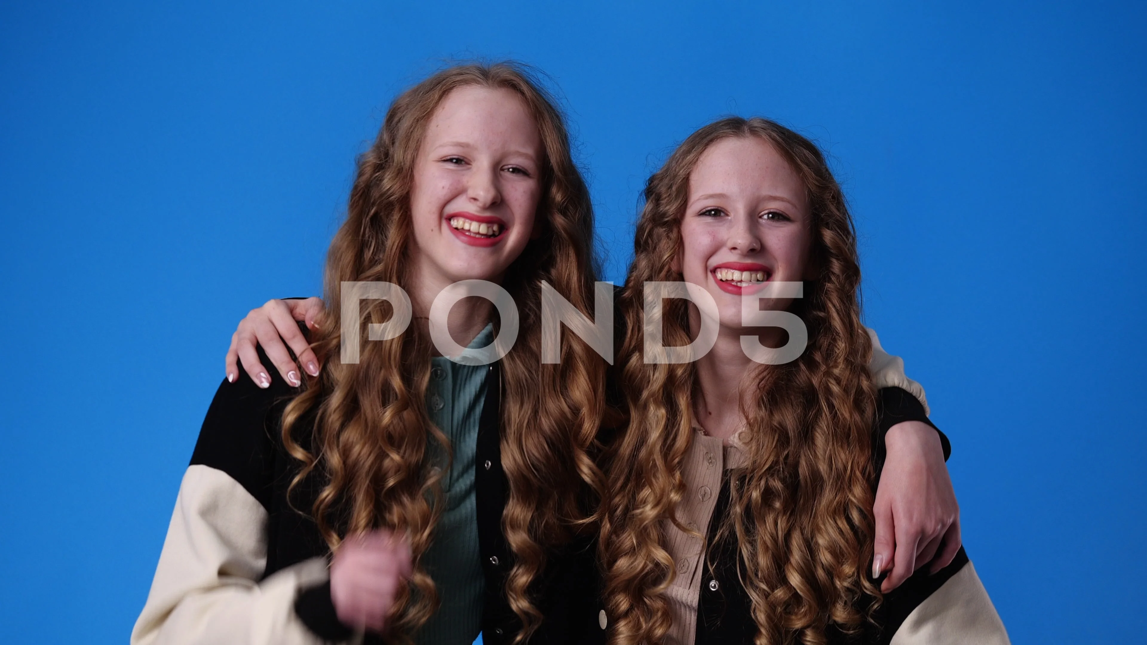 4k video of two twin girls are excited about something over pink background.