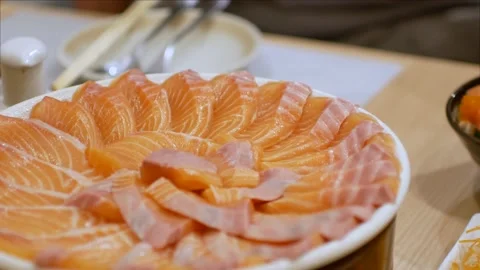 4k video of using chopctick pick slamon up from plate full of salmon sashimi Stock Footage 161889238