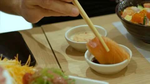 4k video of using chopctick pick slamon sashimi dipping into soy sauce Stock Footage 161889357